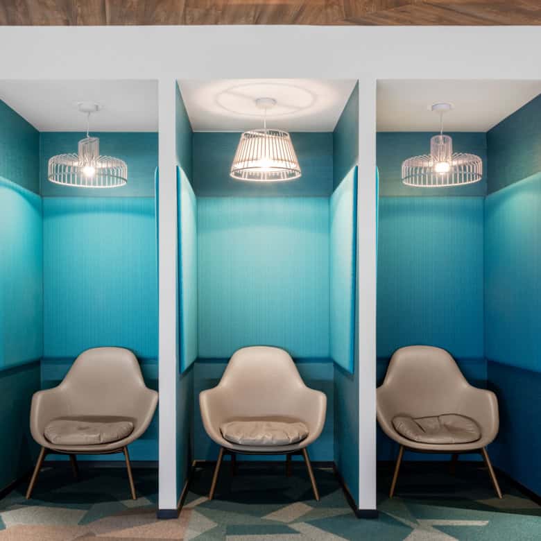 Bright blue soundproof pods with cozy chairs and stylish lighting at Nextspace UAE.