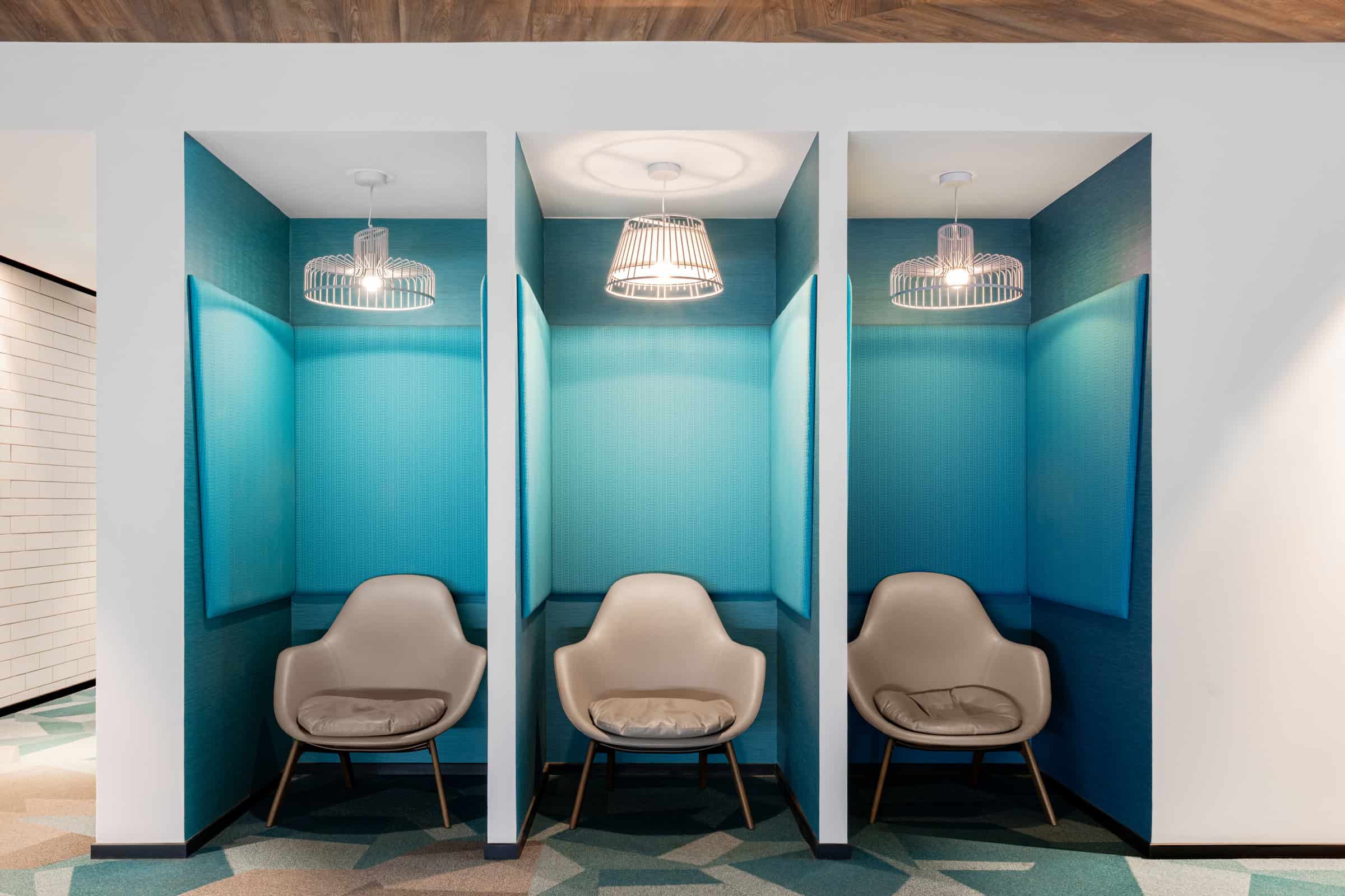 Modern coworking booths at Nextspace UAE, perfect for private work and meetings in Dubai. Bright blue soundproof pods with cozy chairs and stylish lighting at Nextspace UAE.