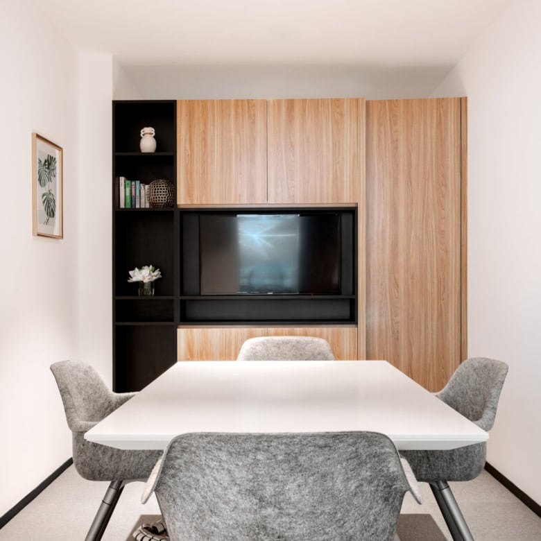 Contemporary coworking space in Dubai with meeting room, TV, and stylish decor.