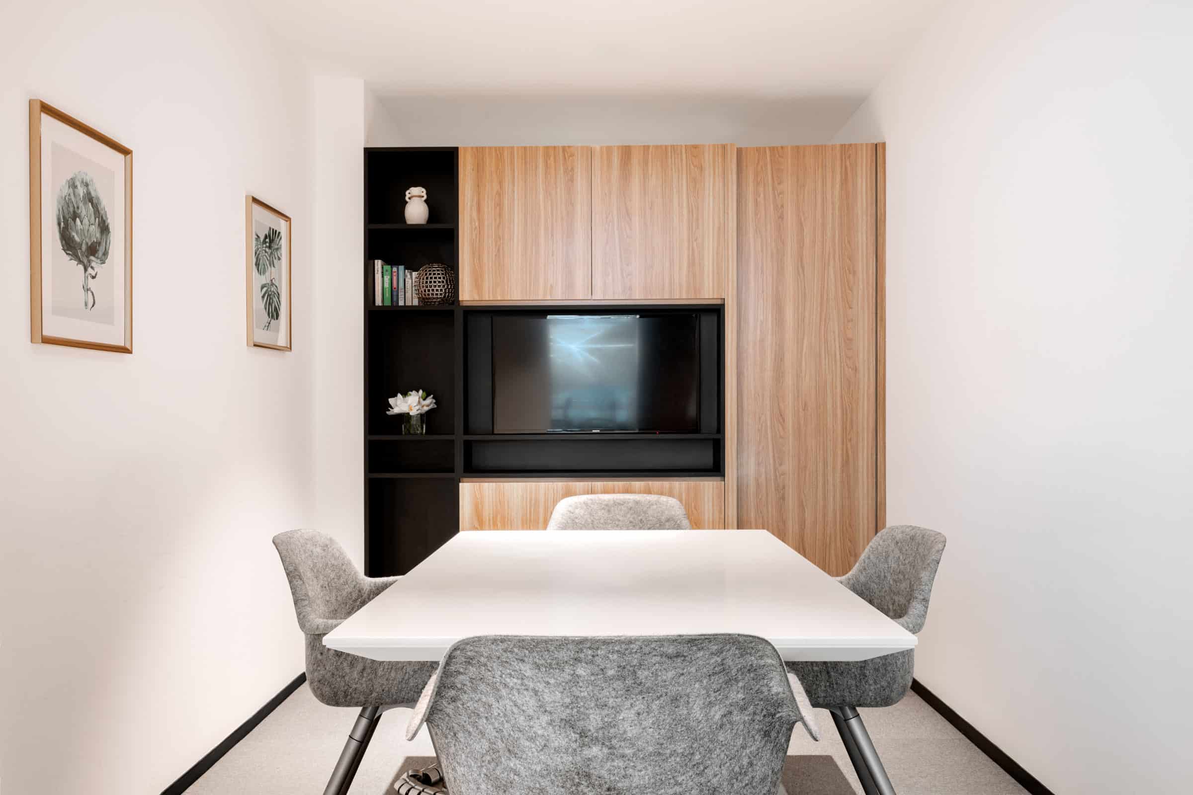 Modern coworking meeting room at Nextspace UAE with comfortable seating and advanced tech. Contemporary coworking space in Dubai with meeting room, TV, and stylish decor.