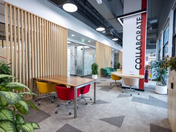 Bright coworking environment in UAE featuring colorful chairs and natural decor for productivity.