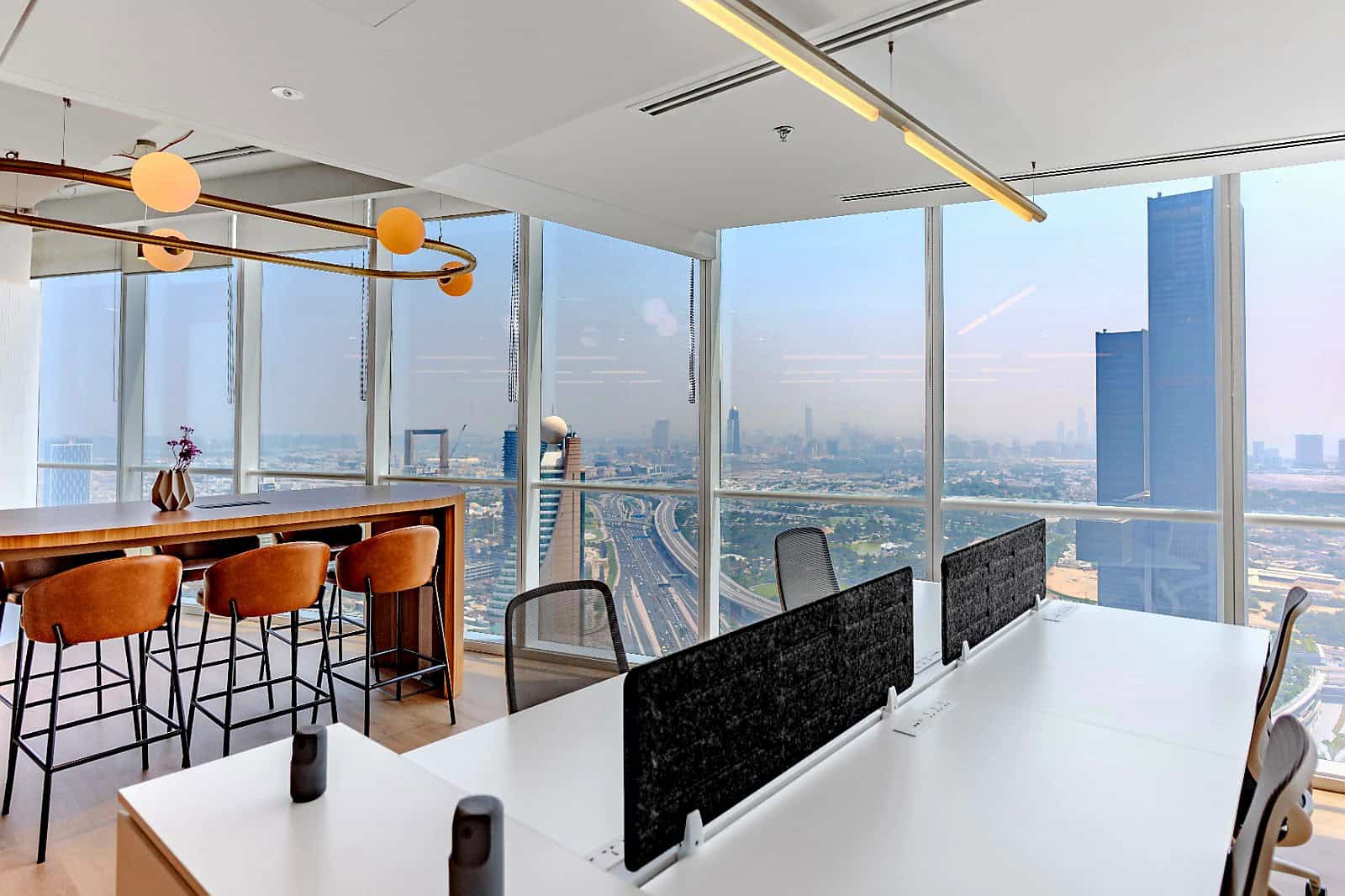 Modern office interior with large glass windows showcasing Dubai cityscape.