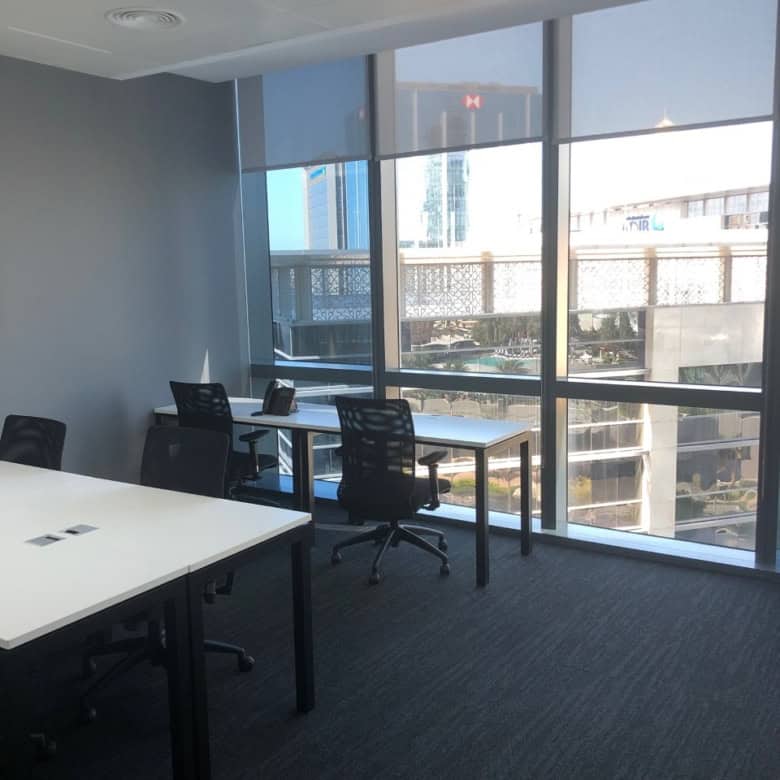 Bright office with large windows and ergonomic chairs in Dubai coworking space.
