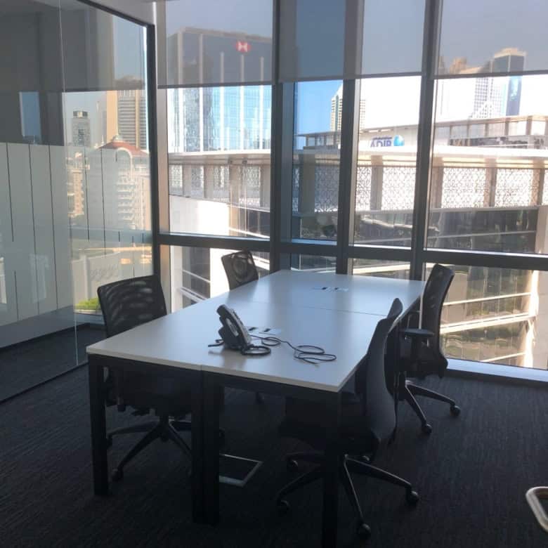 Bright office with large windows, meeting area, and ergonomic chairs in Dubai shared workspace.