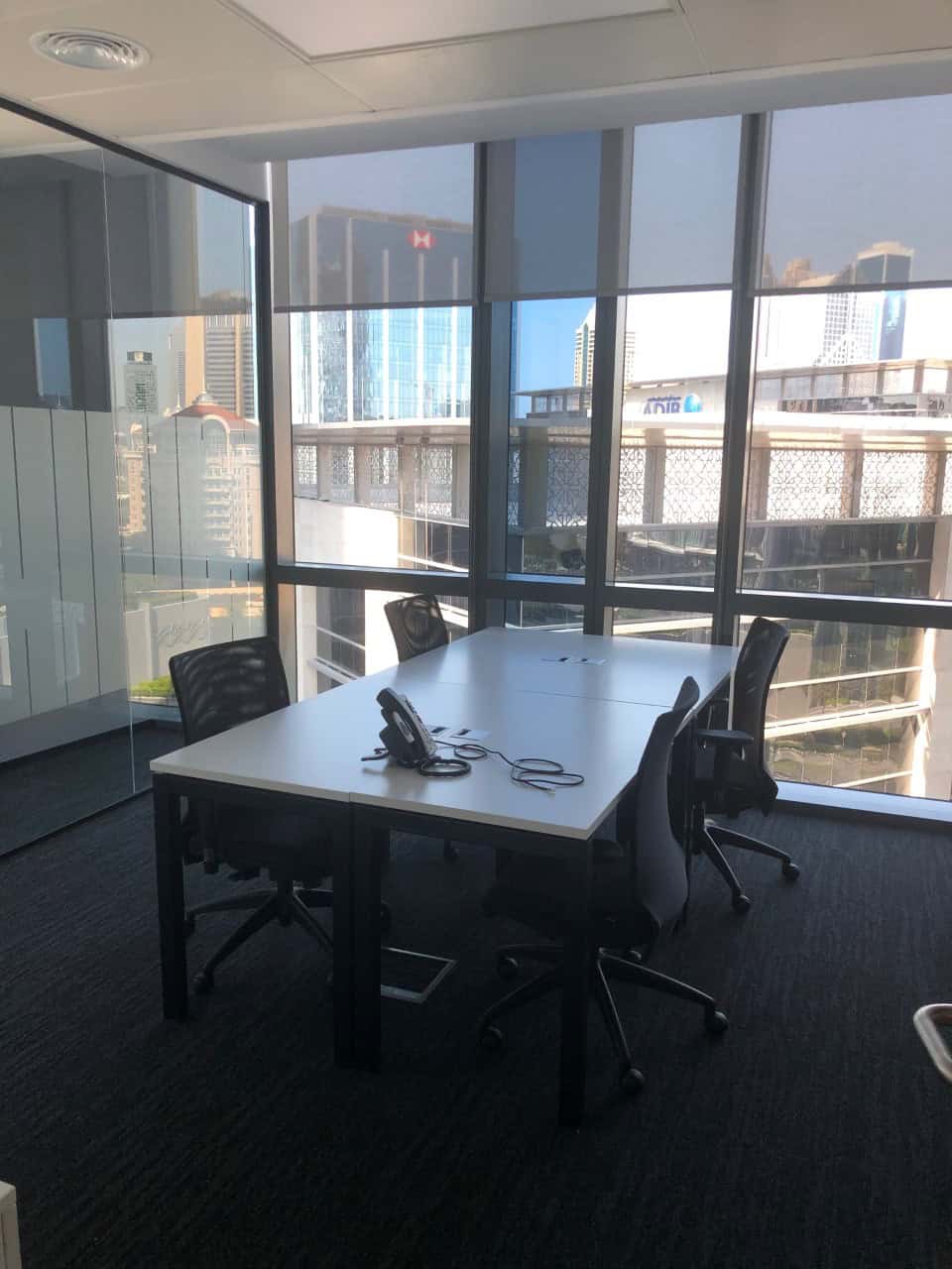 Bright office with large windows, meeting area, and ergonomic chairs in Dubai shared workspace.