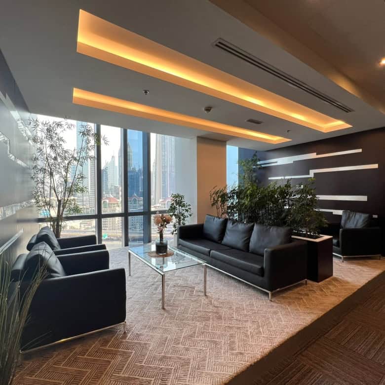 Luxurious coworking space in Dubai with modern furniture, greenery, and stunning skyline vistas.