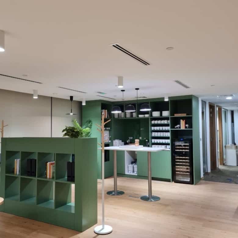 Spacious coworking environment at Nextspace UAE with modern decor and vibrant green accents.