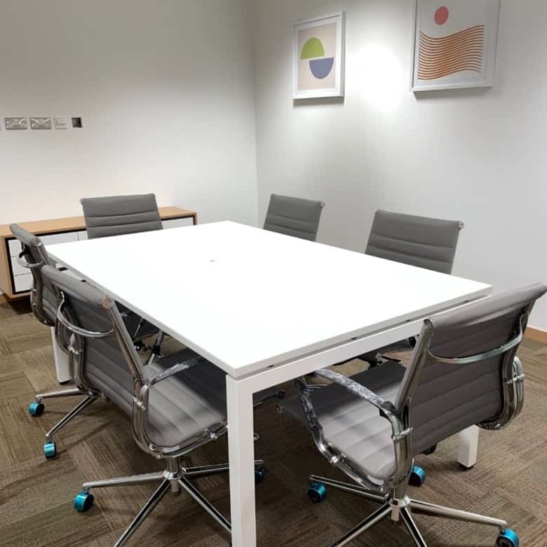 Contemporary meeting room with office chairs, artwork, and bright lighting at Nextspace UAE coworking space.