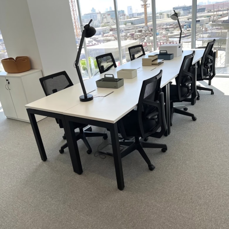 Bright, spacious coworking area with comfortable chairs, desks, and natural sunlight.