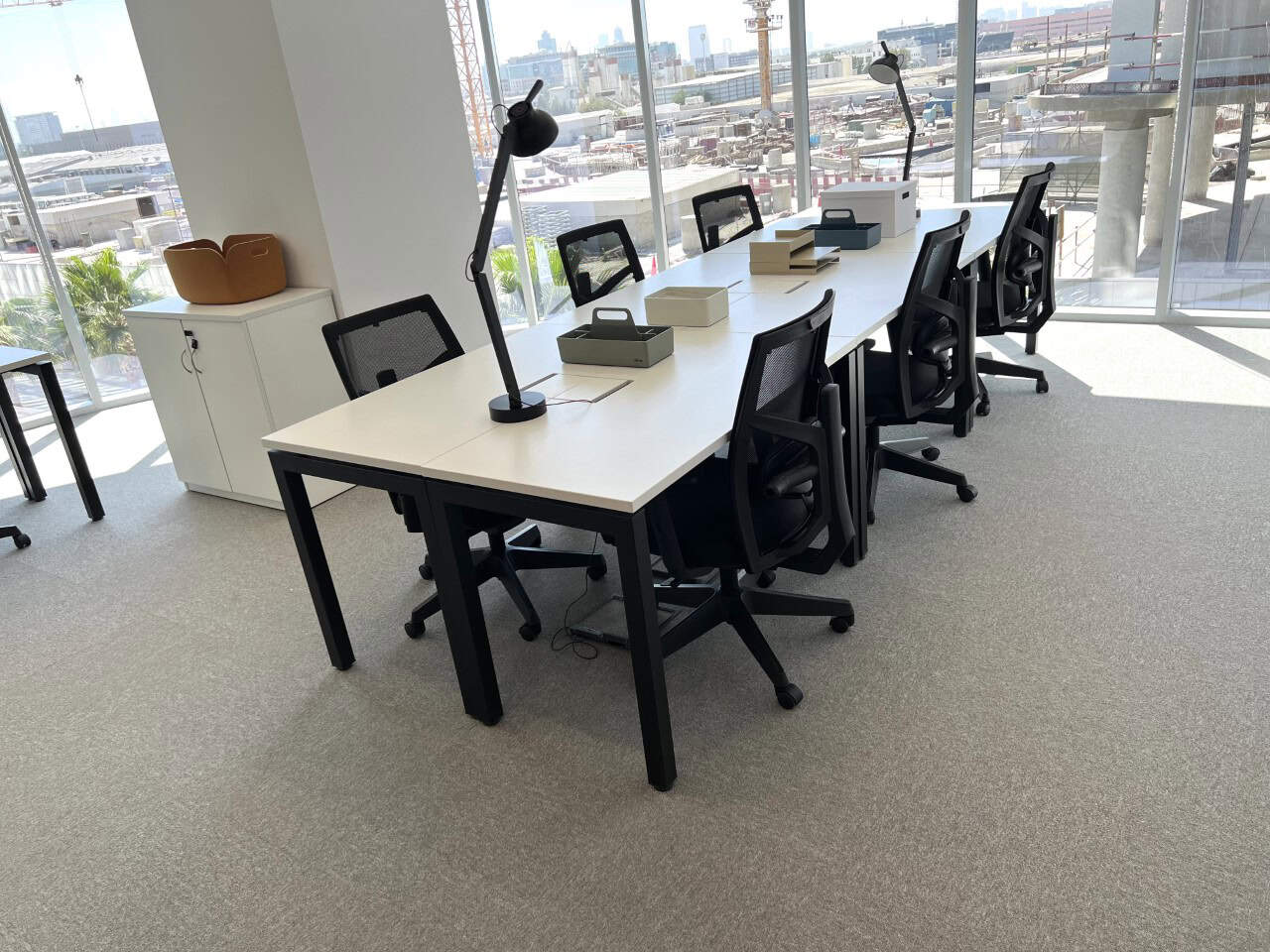 Bright, spacious coworking area with comfortable chairs, desks, and natural sunlight.