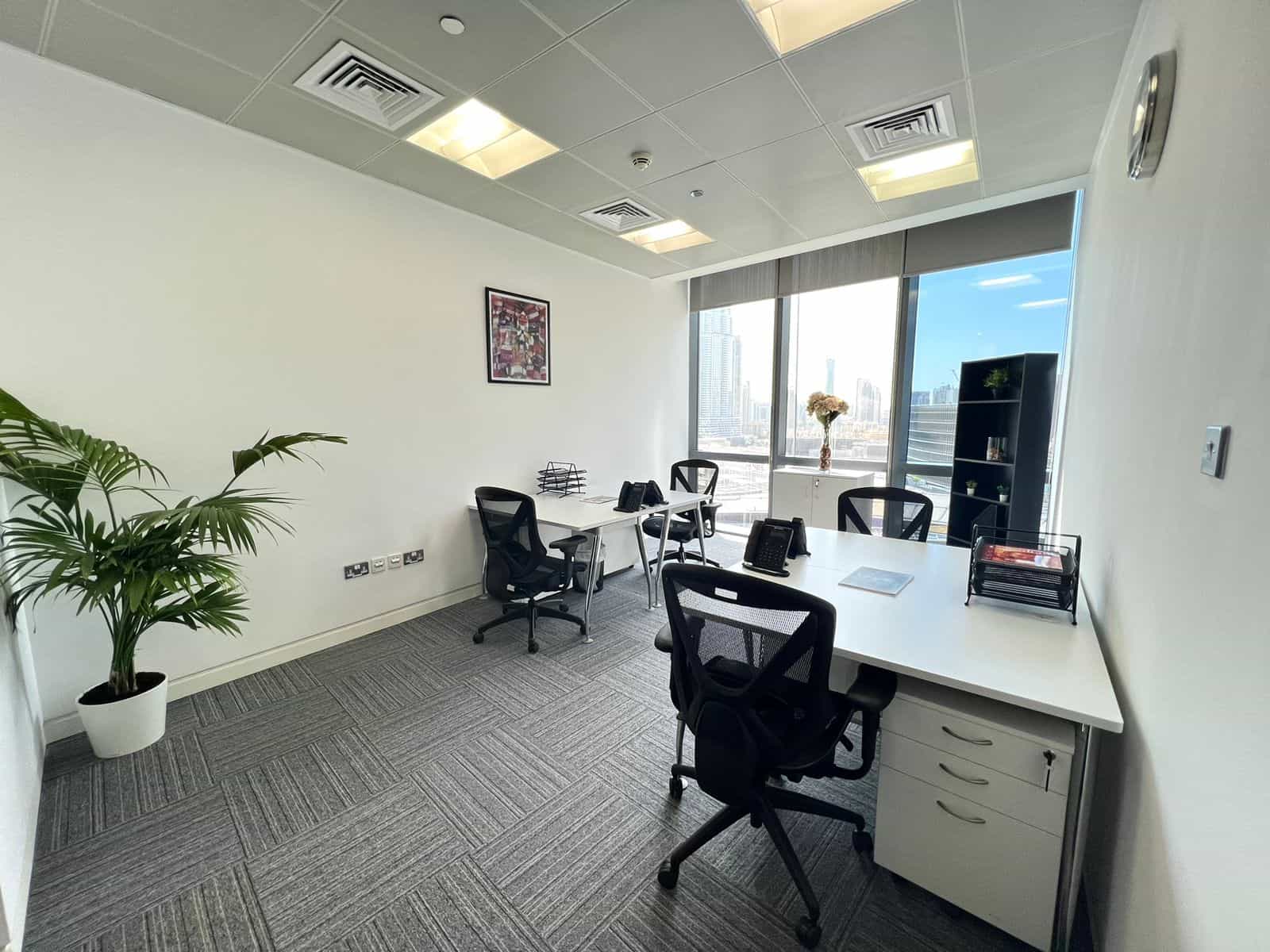 Bright Dubai office with white walls, black chairs, and a cityscape view from large windows.