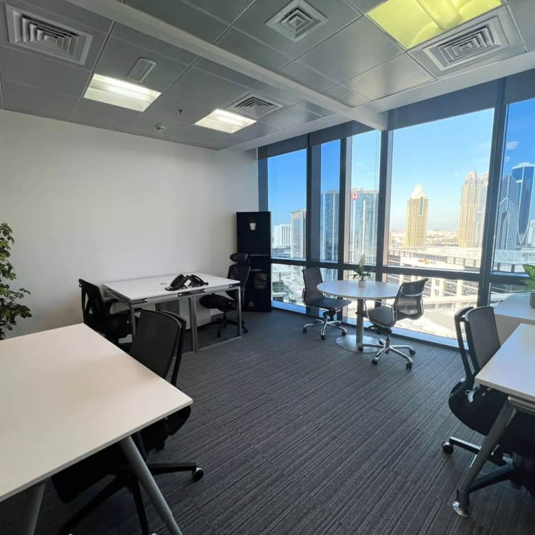 Bright Dubai office with large windows, cityscape view, modern desks, and ergonomic chairs, perfect for coworking at Nextspace UAE.
