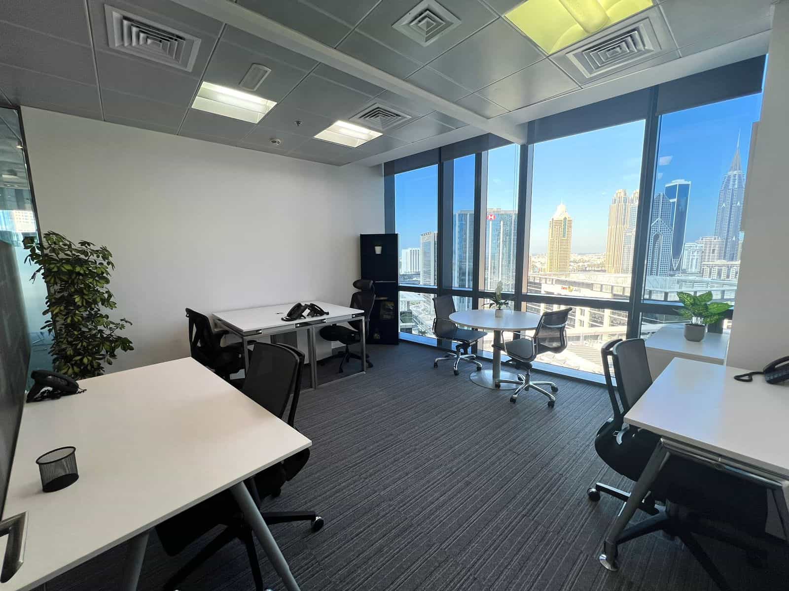 Bright Dubai office with large windows, cityscape view, modern desks, and ergonomic chairs, perfect for coworking at Nextspace UAE.