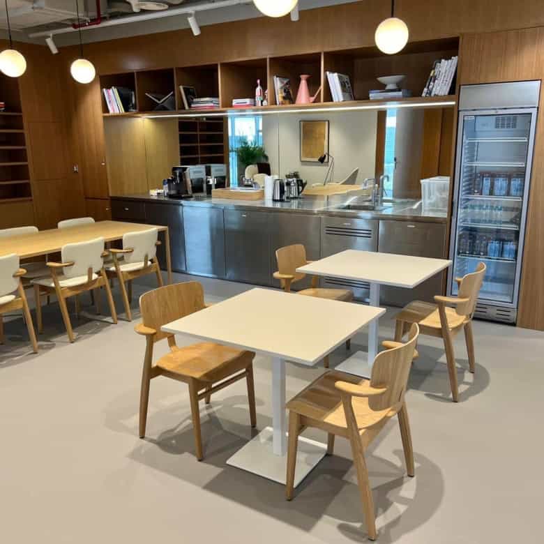 Bright, stylish workspace with modern furniture, kitchenette, and relaxing lounge area in UAE.