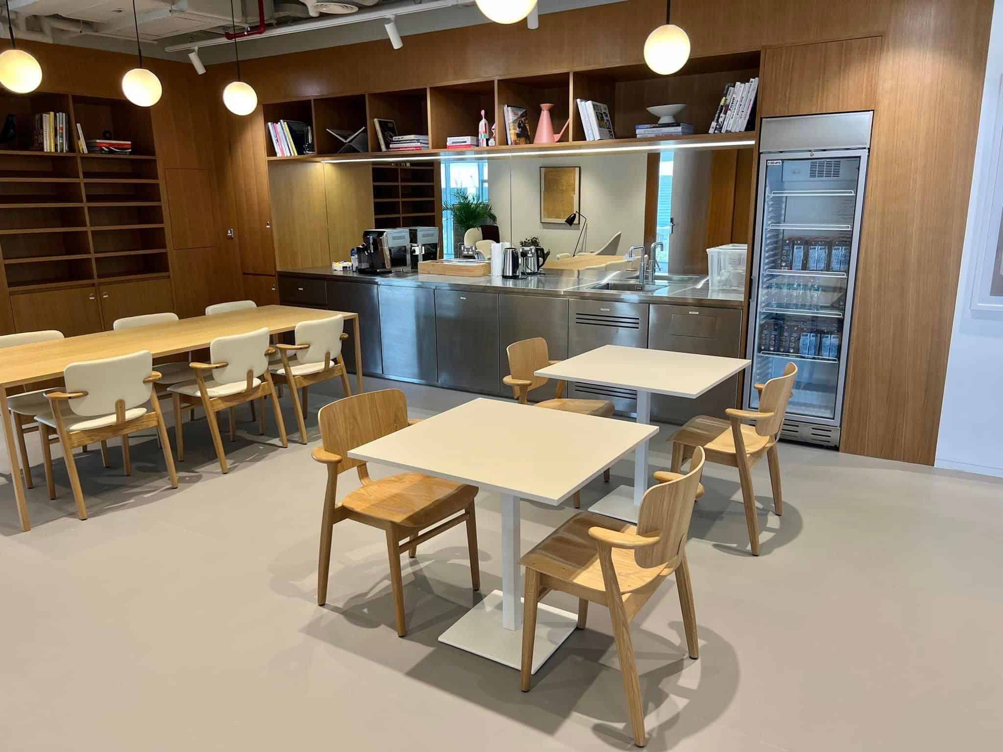 Bright, stylish workspace with modern furniture, kitchenette, and relaxing lounge area in UAE.