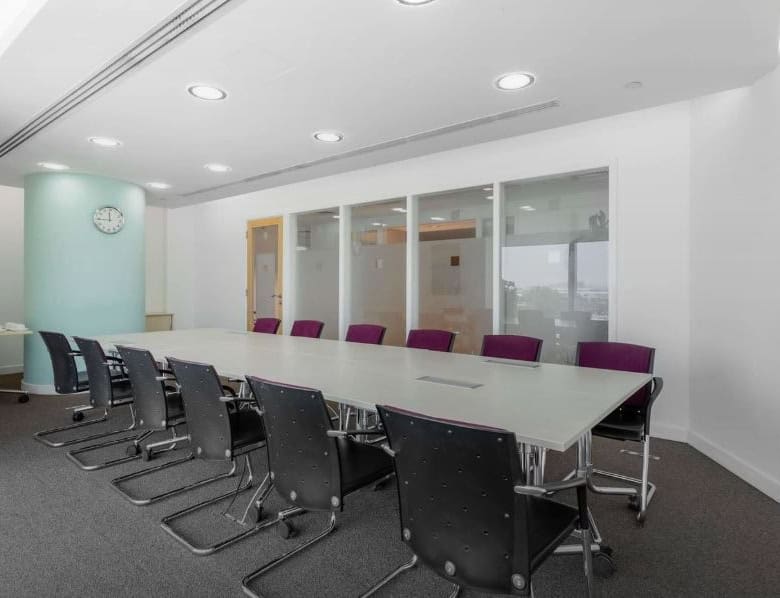 Bright, professional meeting room at Nextspace UAE with modern furniture and glass partitions.