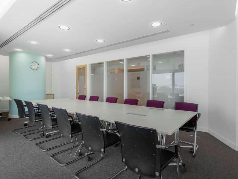 Bright, professional meeting room at Nextspace UAE with modern furniture and glass partitions.
