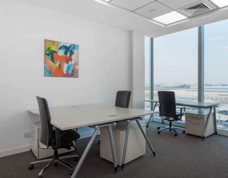Bright office with large windows overlooking Dubai airport.