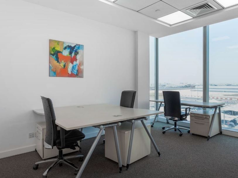Bright office with large windows overlooking Dubai airport.