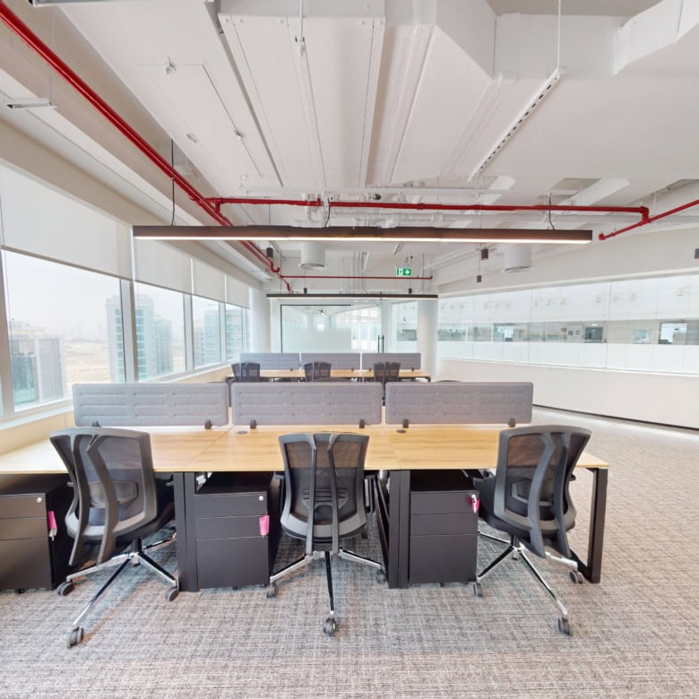 Spacious Dubai office with large windows, ergonomic chairs, and contemporary workspace design.