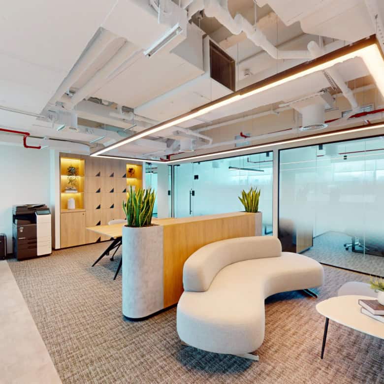 Bright, contemporary office interior with cozy seating and glass meeting rooms in Dubai UAE.