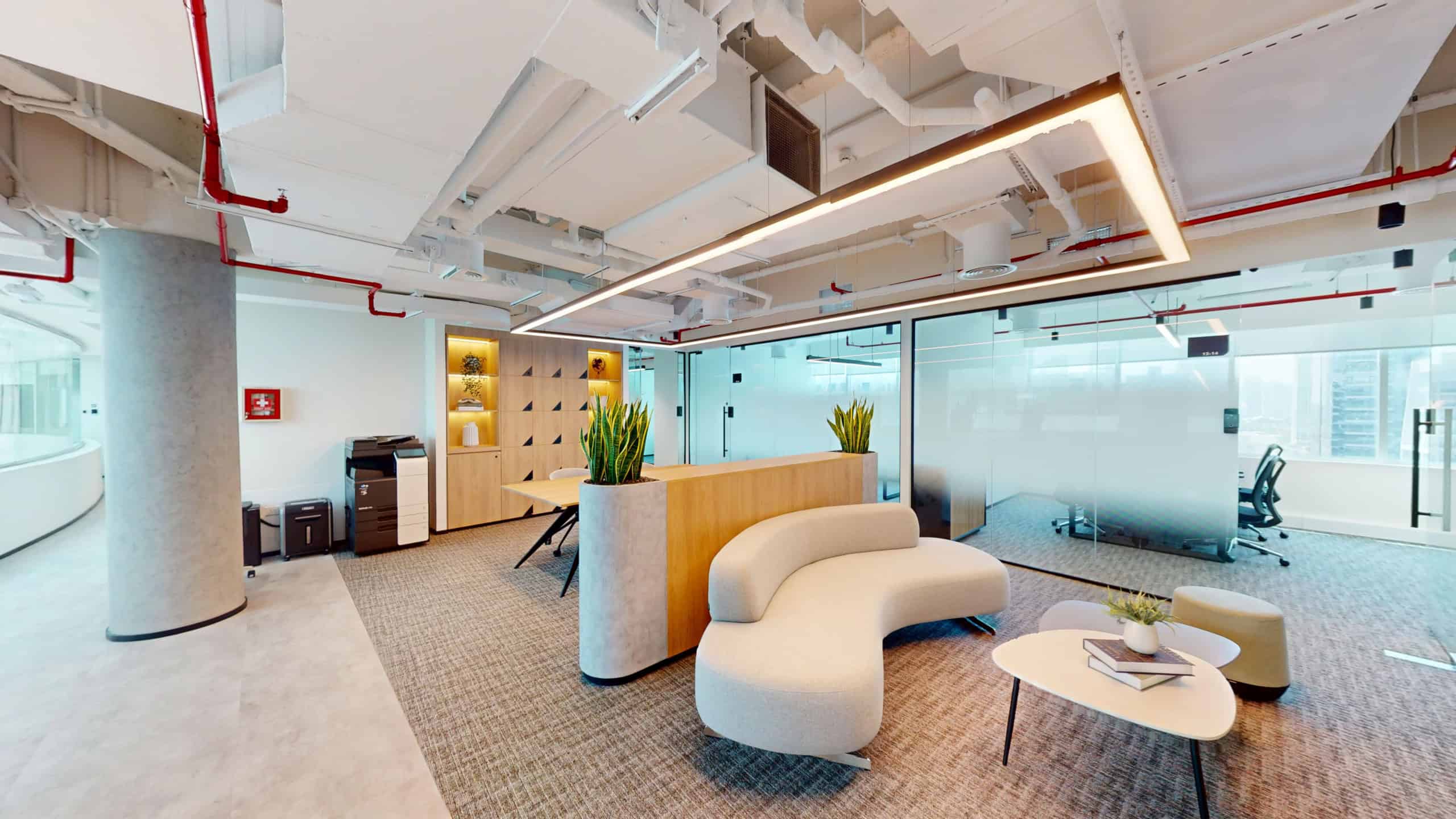 Bright, contemporary office interior with cozy seating and glass meeting rooms in Dubai UAE.