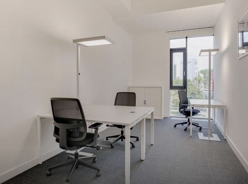 Flexible workspace with ergonomic chairs and natural daylight in Dubai office.