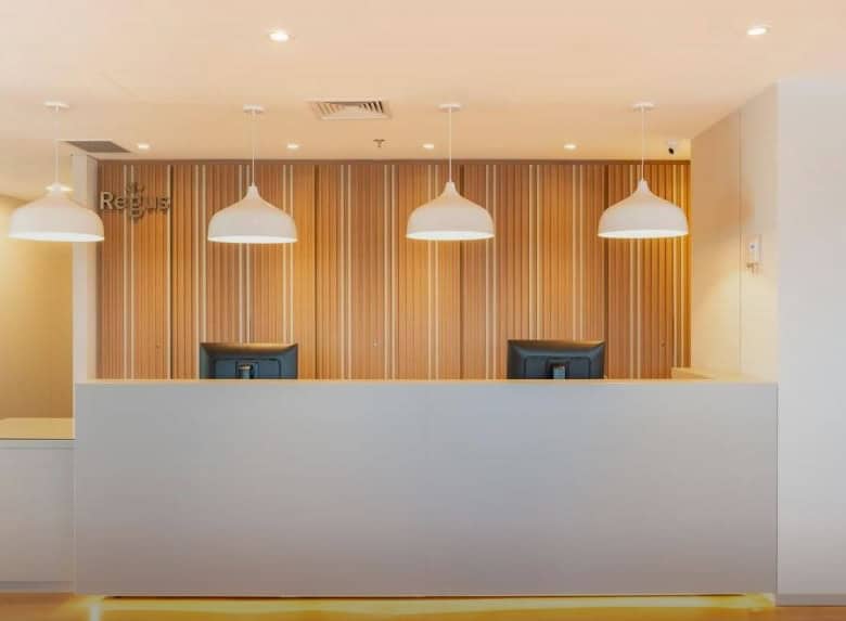 Bright, stylish coworking reception with wooden paneling and contemporary lighting in Dubai Abu Dhabi UAE.