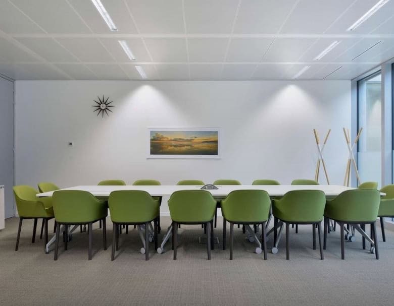 Spacious coworking meeting room with green chairs, modern design, perfect for business events in UAE.