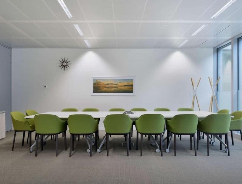 Spacious coworking meeting room with green chairs, modern design, perfect for business events in UAE.