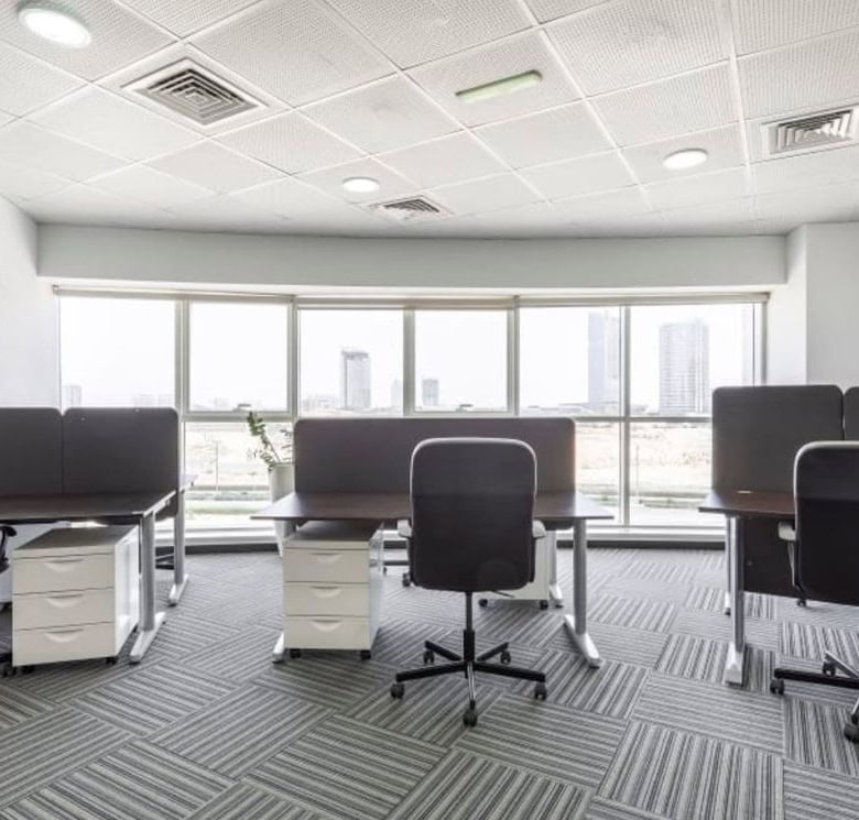 Contemporary office with ergonomic chairs and large windows overlooking Dubai skyline.