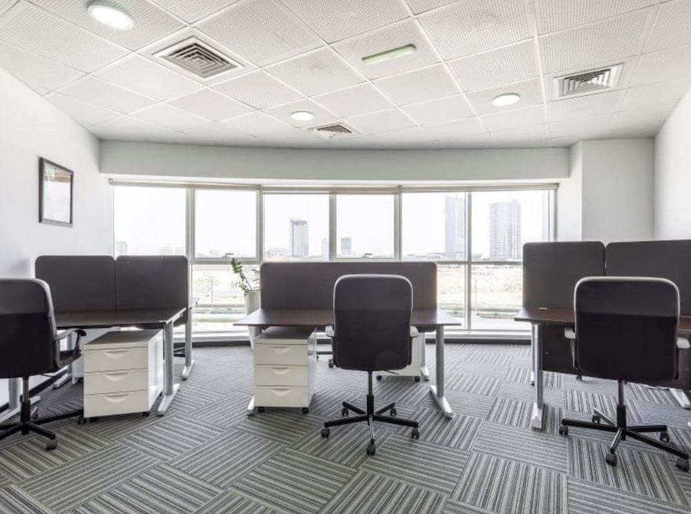 Contemporary office with ergonomic chairs and large windows overlooking Dubai skyline.