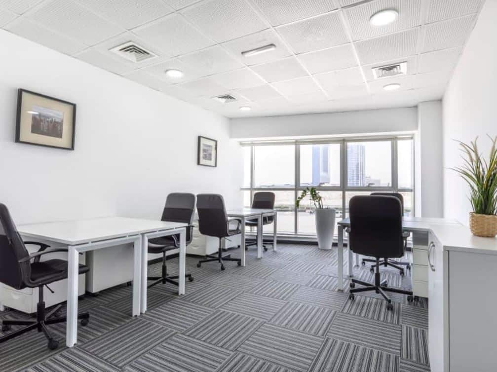 Modern Dubai coworking office with bright natural light, meeting areas, and comfortable desks.