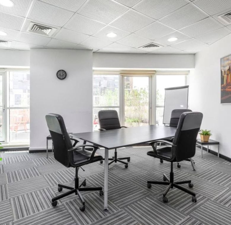 Modern UAE coworking space with meeting table and office chairs.