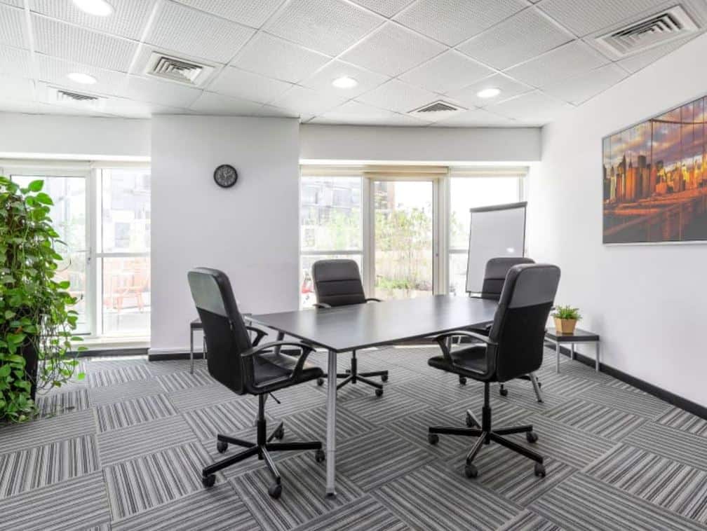 Modern UAE coworking space with meeting table and office chairs.