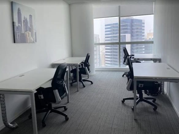 Bright office with workstations and large windows in Nextspace UAE coworking area.