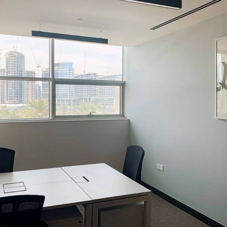 Bright office with large windows and contemporary art in Dubai's business district.