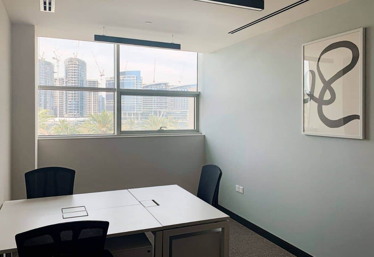 Bright office with large windows and contemporary art in Dubai's business district.