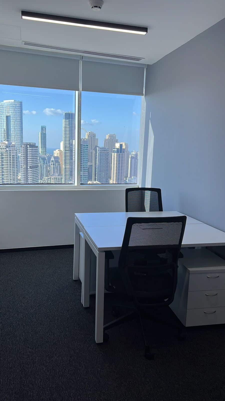 Bright office with cityscape view ideal for startups and freelancers.
