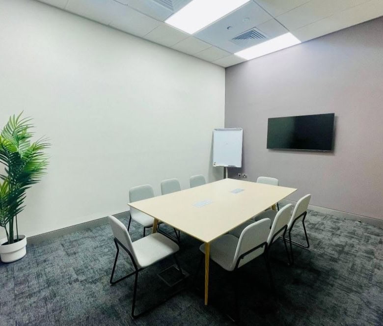 Co-working space in UAE with meeting room, TV display, and modern office amenities.