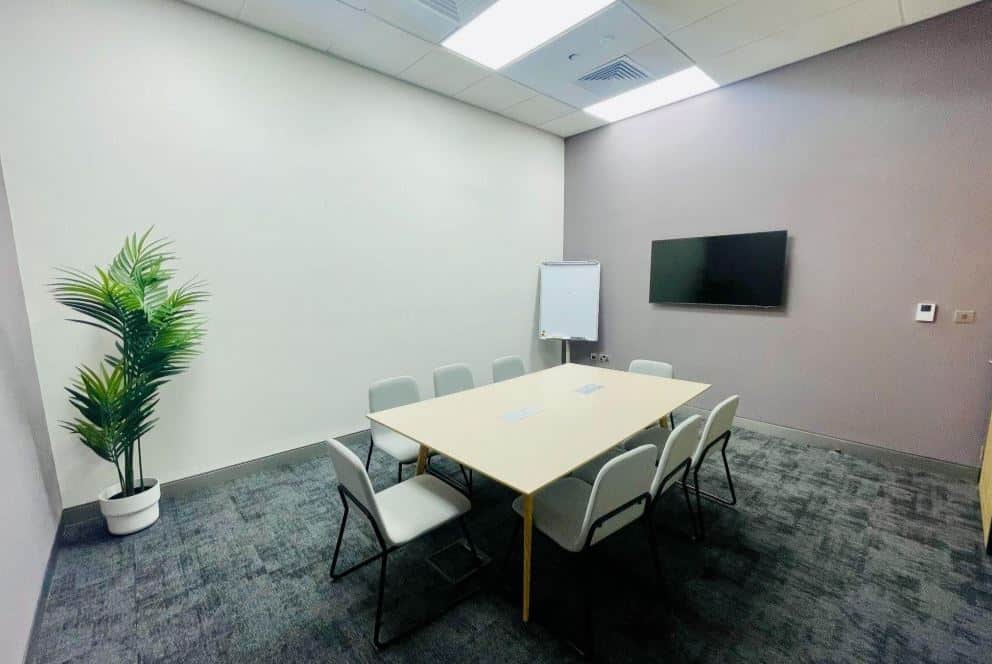 Co-working space in UAE with meeting room, TV display, and modern office amenities.