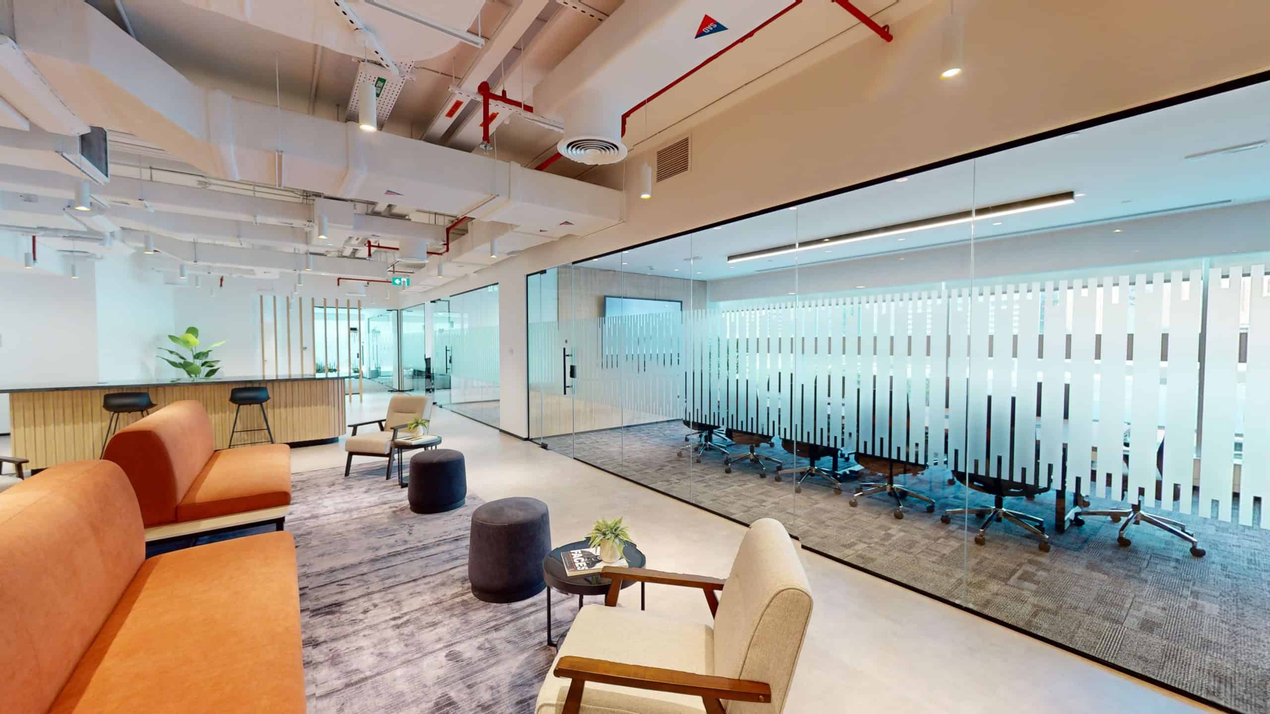 Contemporary Dubai coworking space with lounge area, private offices, and collaborative zones.