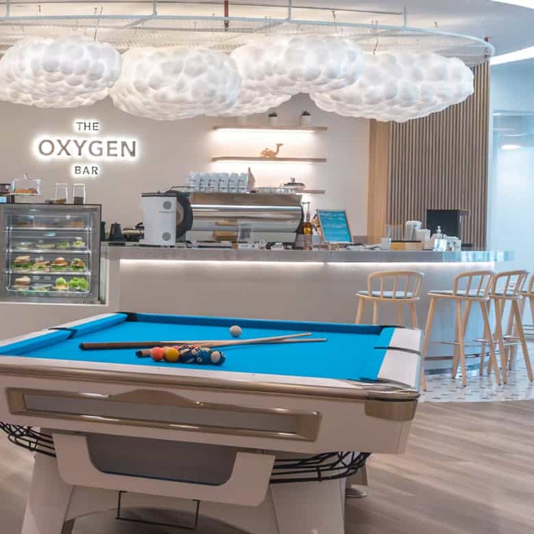 Bright coworking lounge featuring pool table, bar, and relaxed seating at Nextspace UAE.