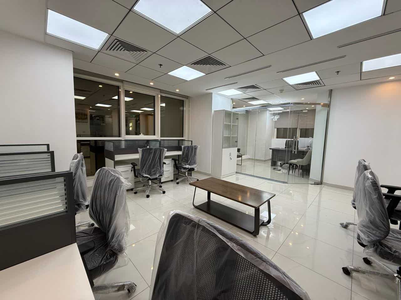 Bright and sleek office interior with ergonomic chairs and glass-walled conference rooms.