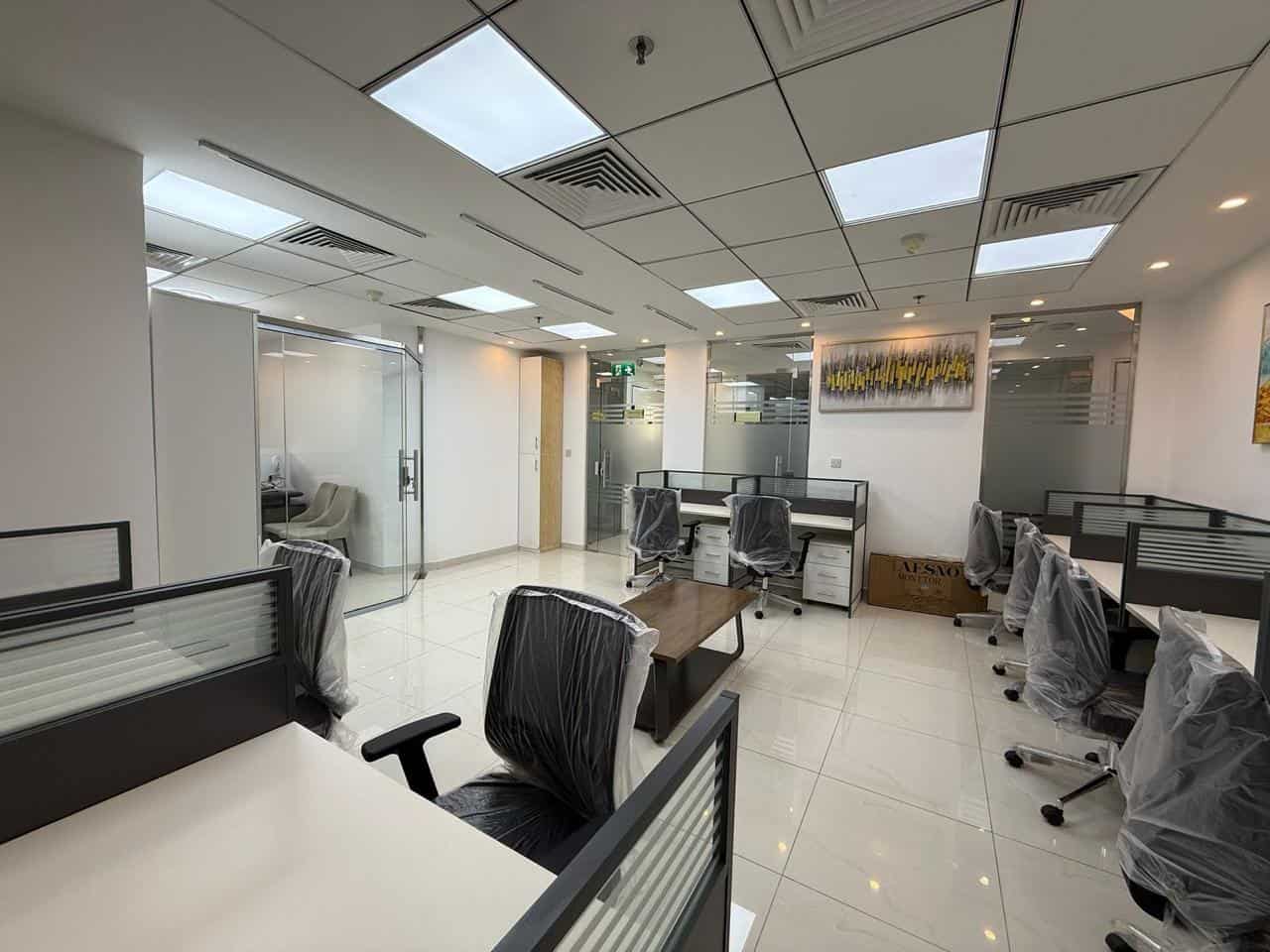 Bright, contemporary coworking workspace with individual desks, ergonomic chairs, and meeting areas in Dubai.