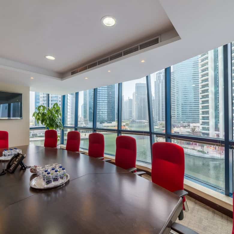 Bright office meeting room with large windows overlooking Dubai skyline, perfect for startups and remote teams.