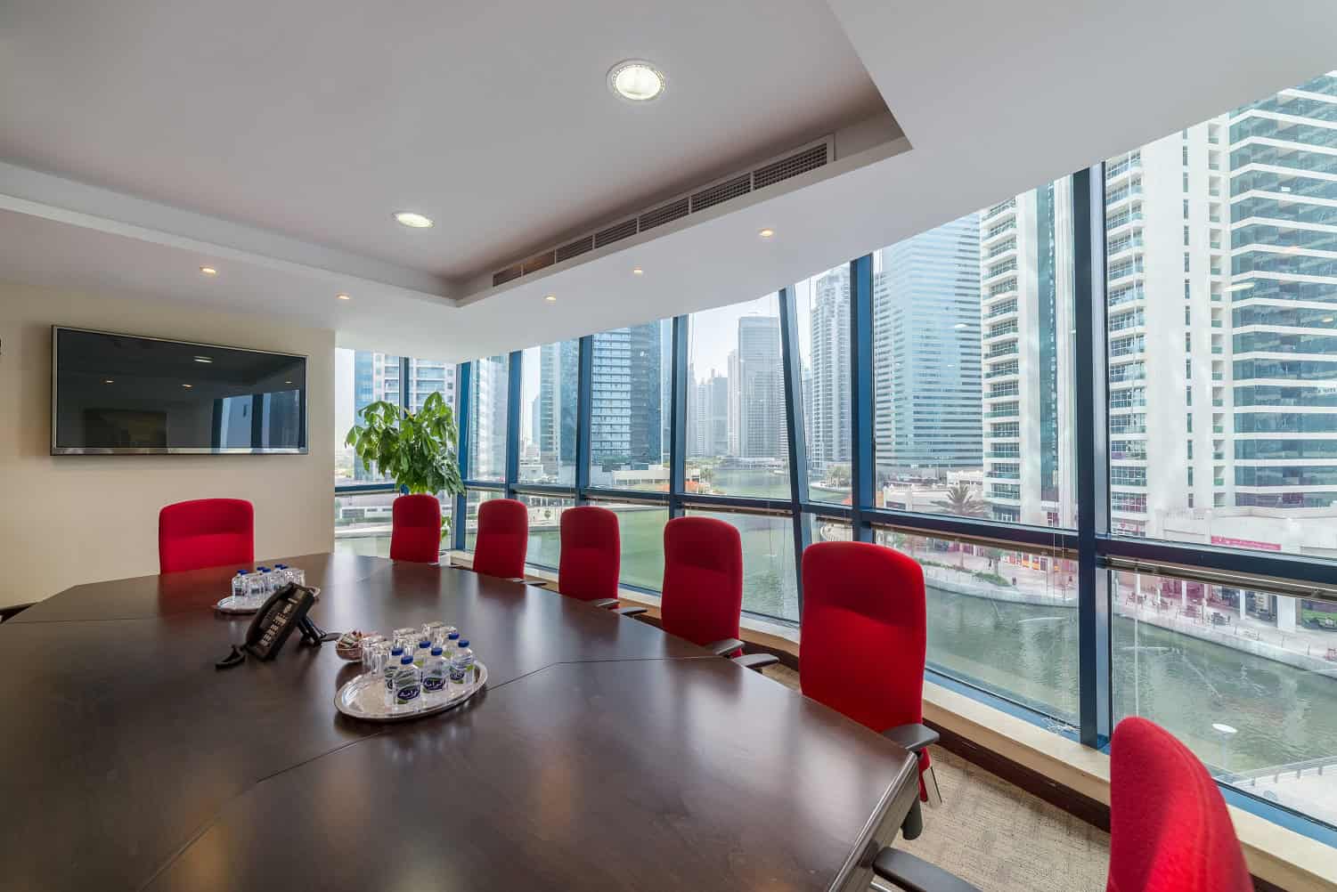 Bright office meeting room with large windows overlooking Dubai skyline, perfect for startups and remote teams.