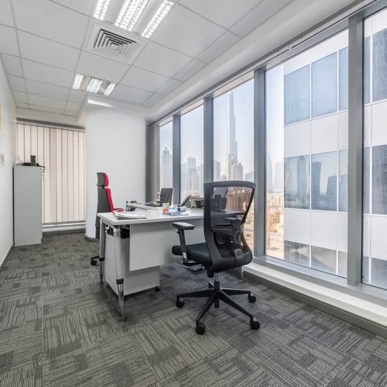 Bright office with large windows offering stunning Dubai skyline views, ideal for coworking and private offices.