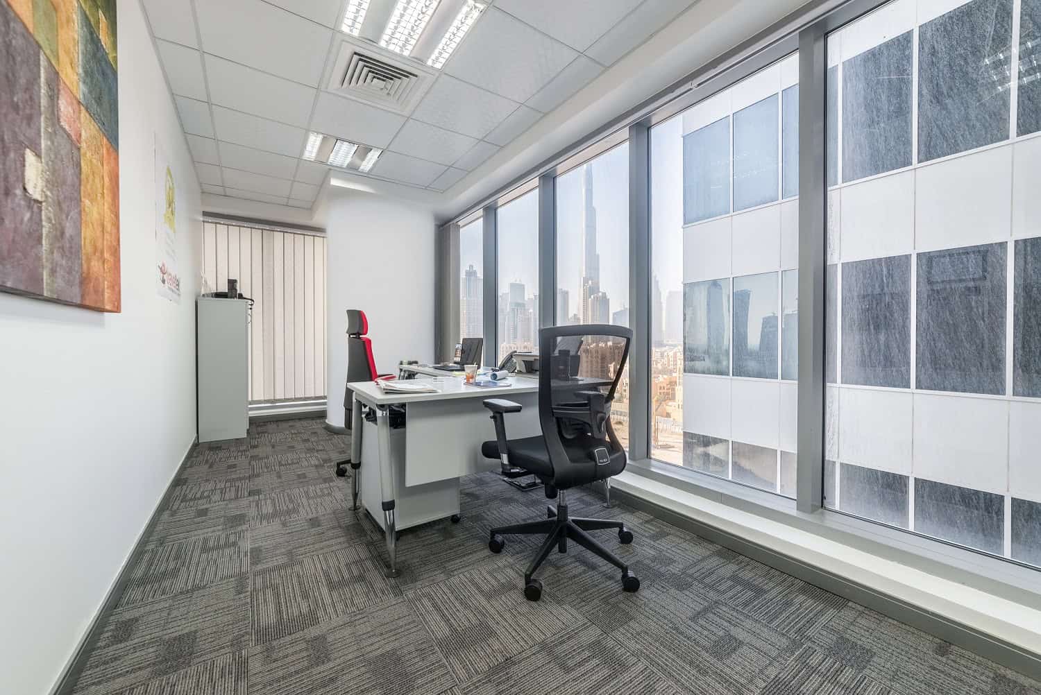 Bright office with large windows offering stunning Dubai skyline views, ideal for coworking and private offices.