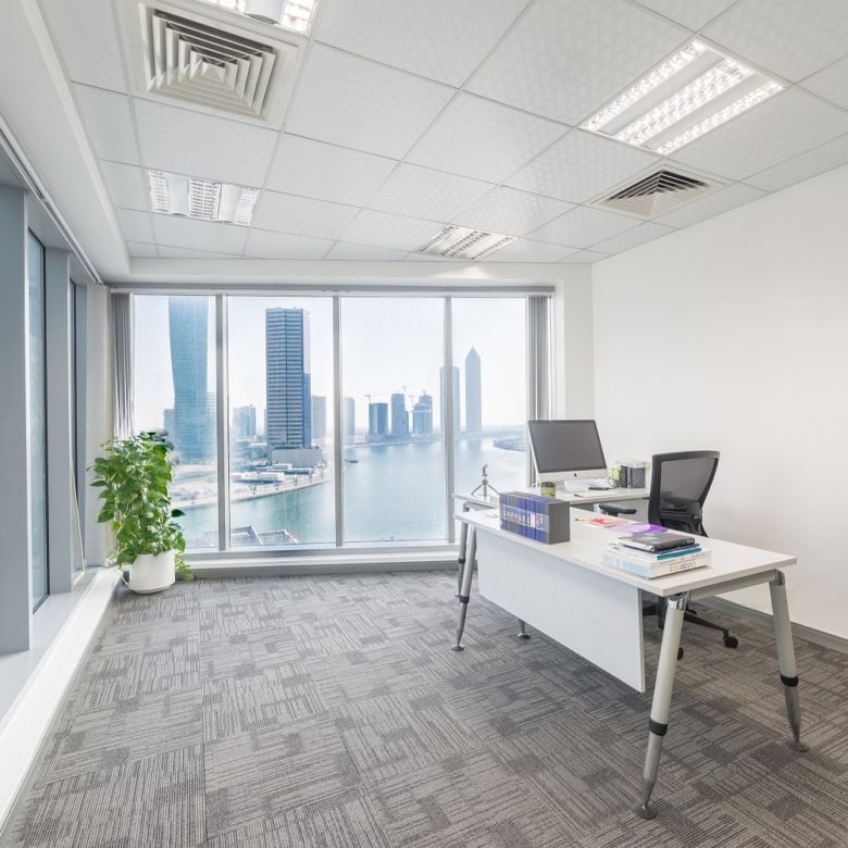 Bright office with large windows overlooking Dubai's skyline and water, ideal for productivity and business growth.